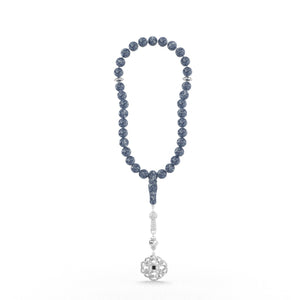 Silver tasbih with blue beads and a detailed silver pendant featuring a Quran-inscribed nano chip, displayed on a white background.