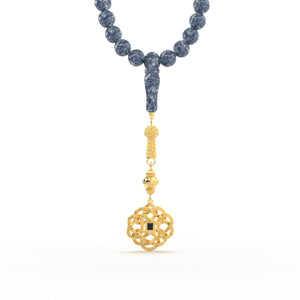 Gold tasbih with blue beads and a decorative gold pendant featuring a Quran-inscribed nano chip, displayed on a white background.