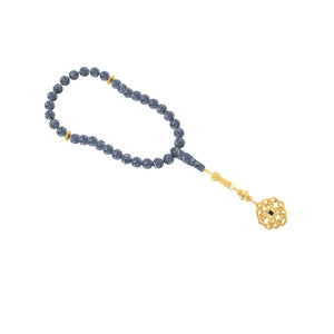 Gold tasbih with blue beads and a decorative gold pendant featuring a Quran-inscribed nano chip, displayed on a white background.