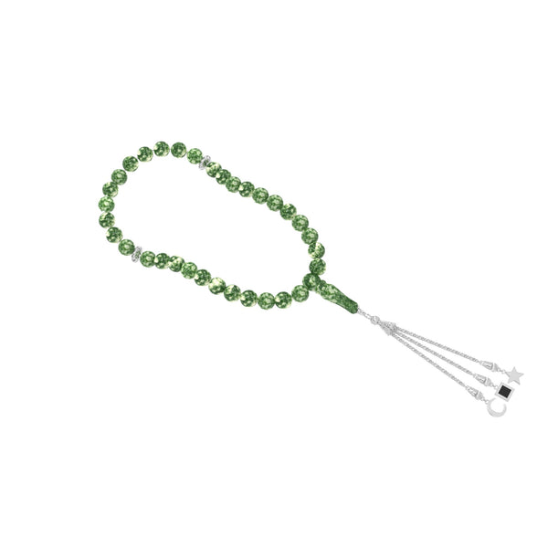 Close-up of a person holding a green gemstone tasbih with gold-plated tassels, featuring an embedded nano chip with the entire Quran.