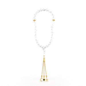 Gold tasbih with white stones and a gold pendant containing a Quran-inscribed nano chip, displayed on a white background.