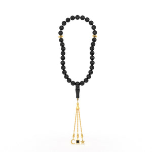 Gold tasbih with black beads and a gold tassel featuring three pendants, with the central square pendant containing a black nano chip inscribed with the entire Quran, displayed on a white background.