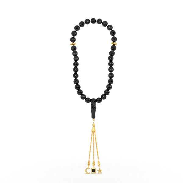 Gold tasbih with black beads and a gold tassel featuring three pendants, with the central square pendant containing a black nano chip inscribed with the entire Quran, displayed on a white background.