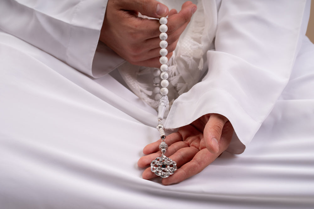 Gold tasbih with white stones and a decorative gold pendant featuring a nano chip micro engraved with the entire Quran.