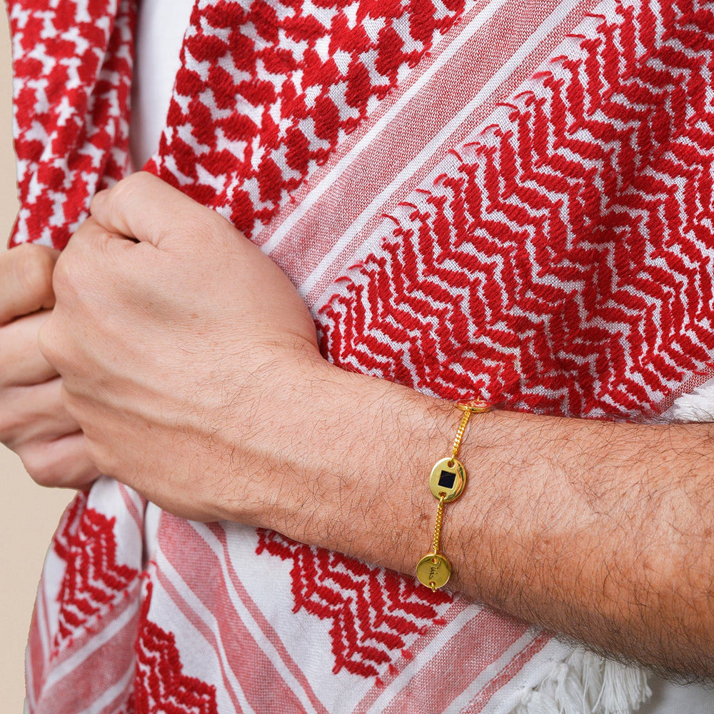 Gold bracelet with three round-and-square pendants, featuring a central square black nano chip inscribed with the entire Quran, displayed on a white background.