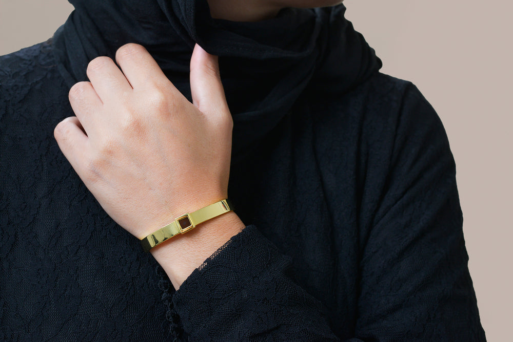 Silver cuff bracelet featuring a built-in black nano chip containing the full Quran, displayed on a white background.