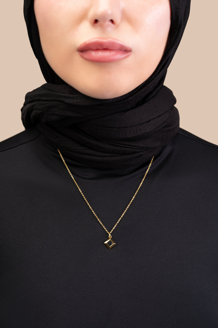 Silver necklace with a square black nano-chip pendant containing a Quran-inscribed nano chip, displayed on a white background.