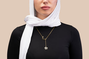Gold necklace featuring a crescent and star pendant, with the star containing a black nano chip inscribed with the entire Quran, displayed on a white background.