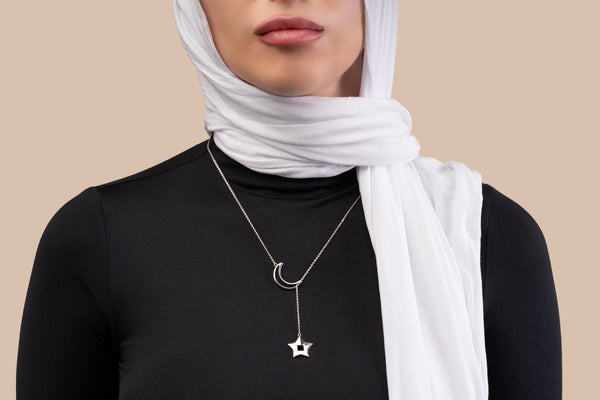 Gold necklace featuring a crescent and star pendant, with the star containing a black nano chip inscribed with the entire Quran, displayed on a white background.
