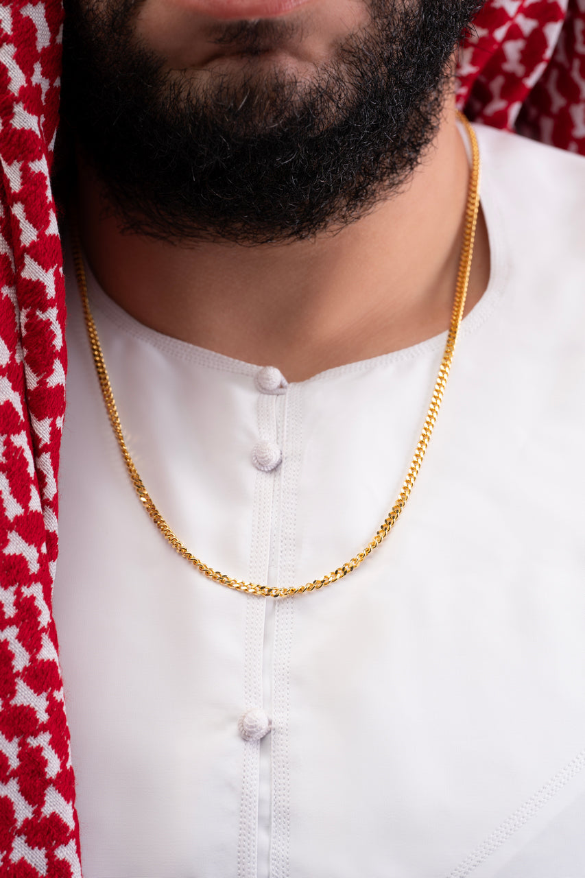 Gold Cuban chain necklace featuring a black nano chip near the clasp that contains the full Quran, displayed on a white background.