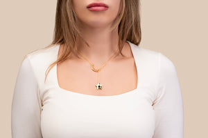 Gold necklace featuring a crescent and star pendant, with the star containing a black nano chip inscribed with the entire Quran, displayed on a white background.